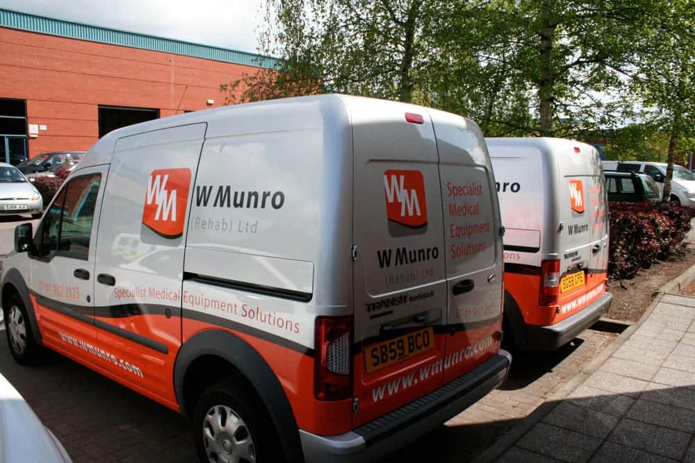 Two W Munro vans in grey with bold orange and red livery